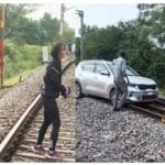 women drive car in railway track